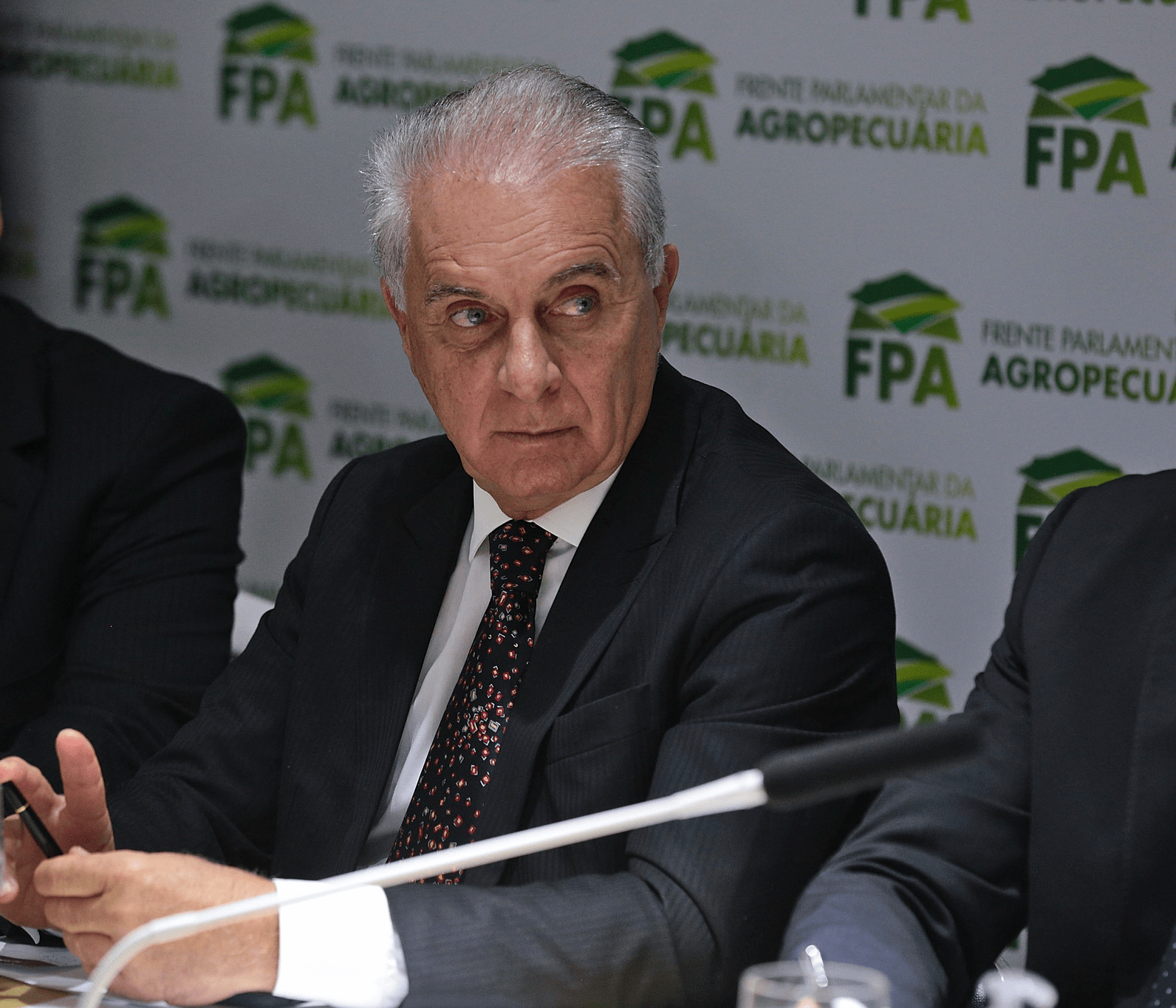 Foto de Marcos Pontes sentado em frente a painel da Frente Parlamentar da Agropecuária (FPA).