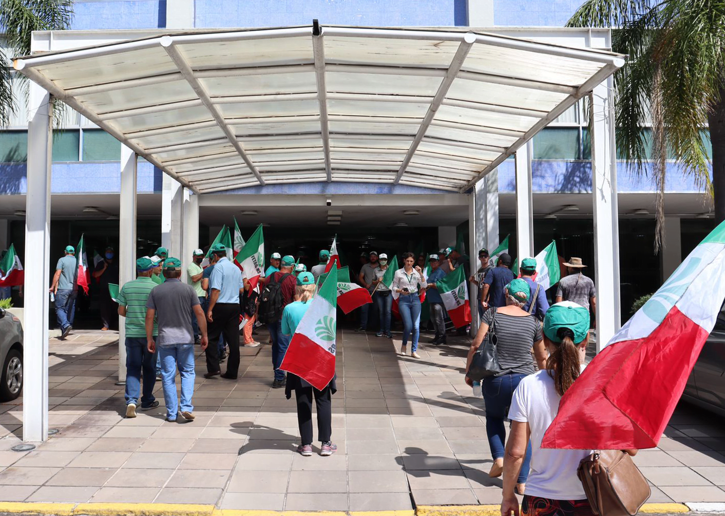 Foto de pessoas protestam em frente à edifício.