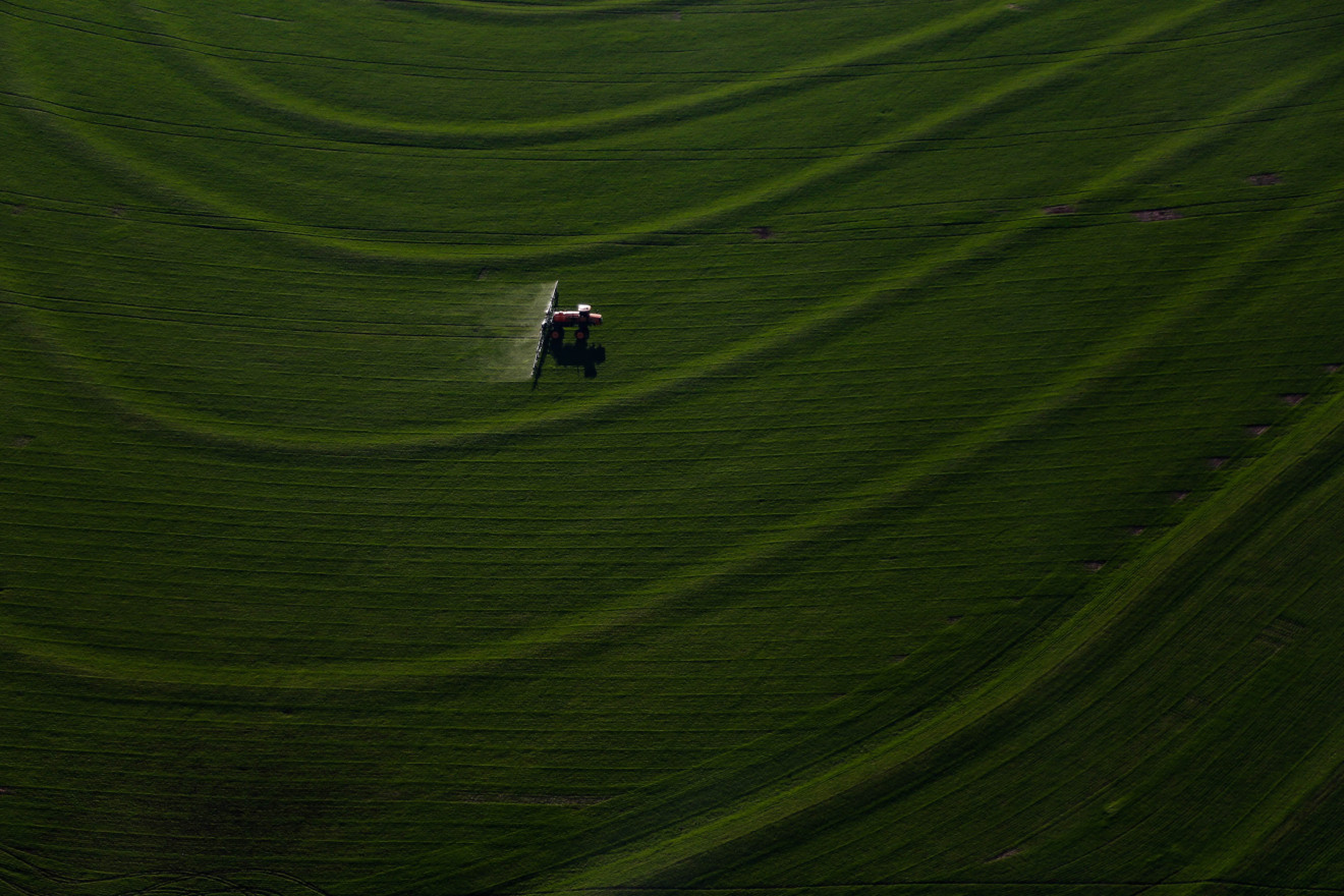 Máquina agrícola realizando tratamento em lavoura.
