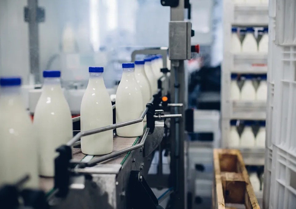 Garrafas com leite, em uma máquina de fábrica