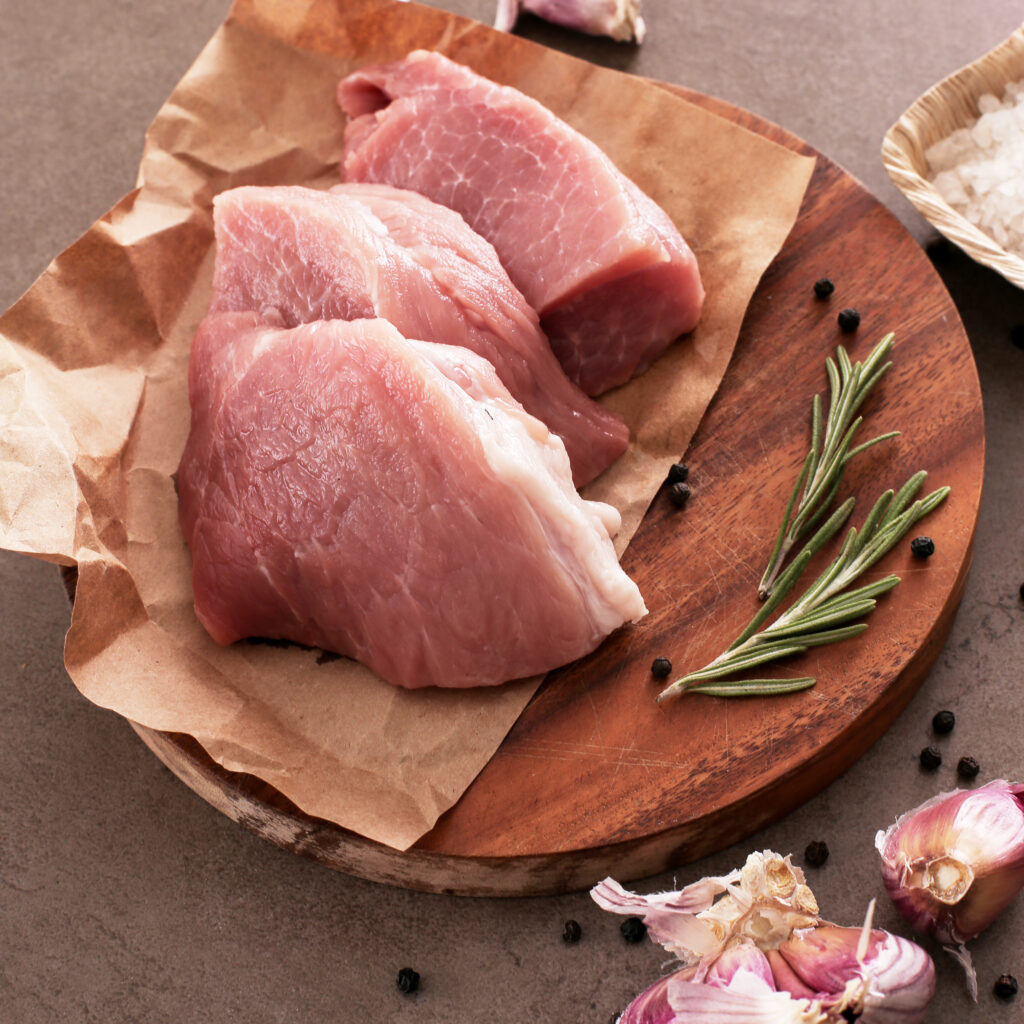 carne de suíno crua, em cima de uma tábua
