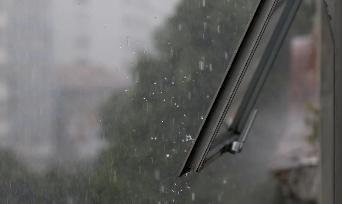 Foto de janela aberta com chuva do lado de fora.