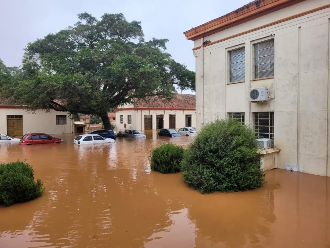 Foto de prédios antigos e carros rodeados por água.