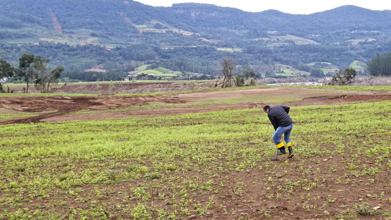 Foto de homem trabalhando em meio a campo.