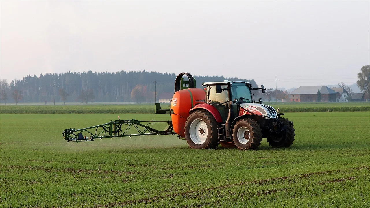Foto de máquina agrícola aplicando defensivo em lavoura.
