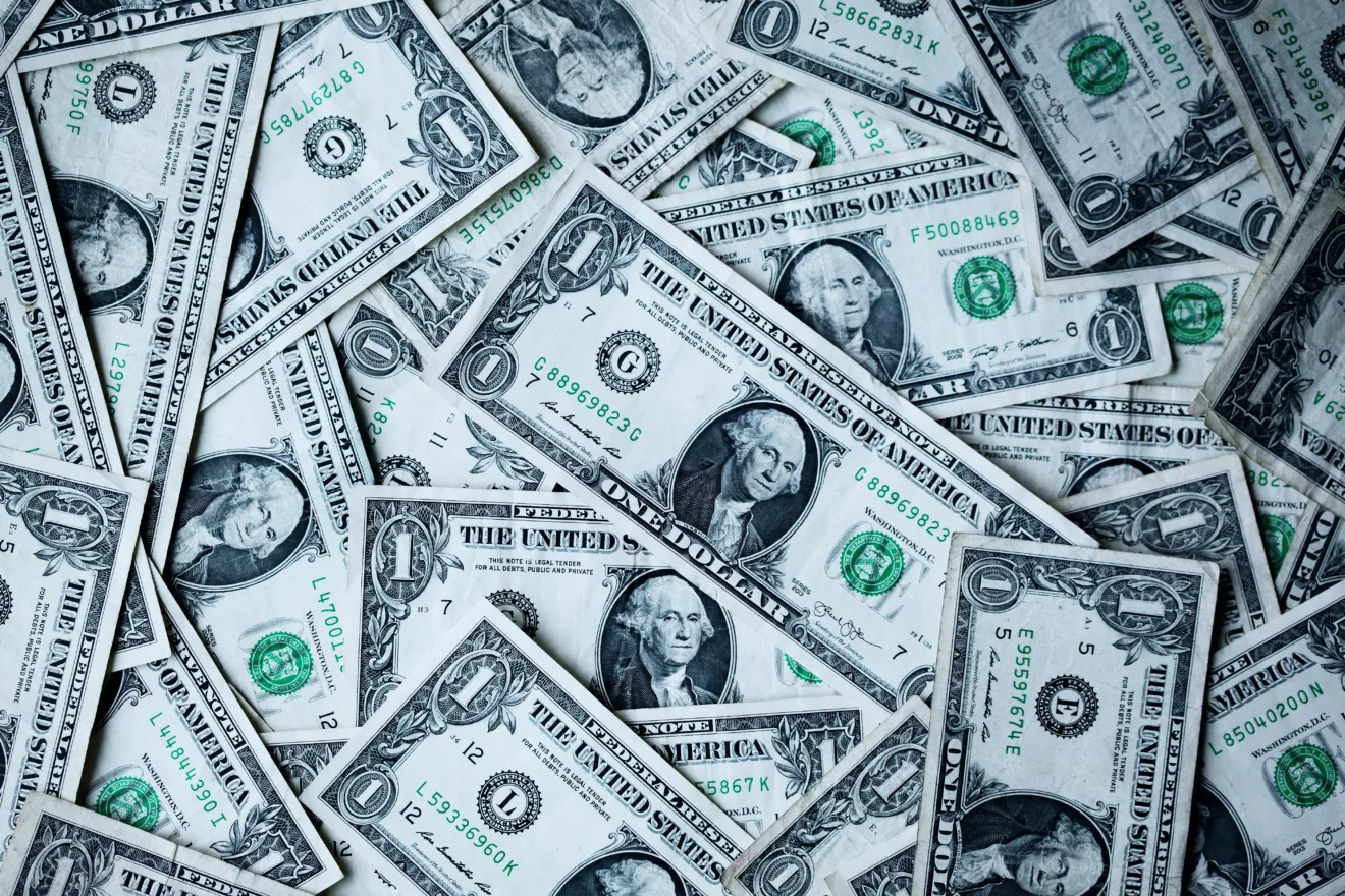 Fotos de notas de dólar espalhadas.