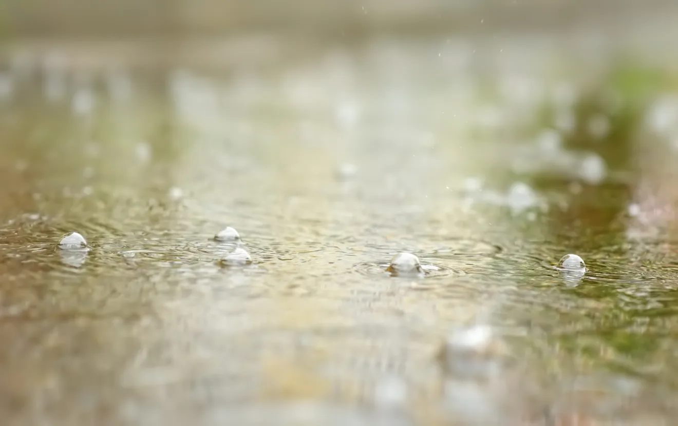 Foto de gotas de água caindo em poça.