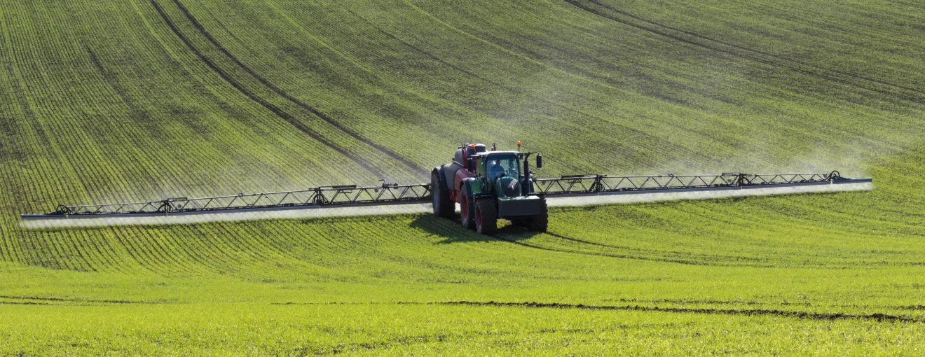 Foto de pulverizador aplicando fertilizantes em lavoura.
