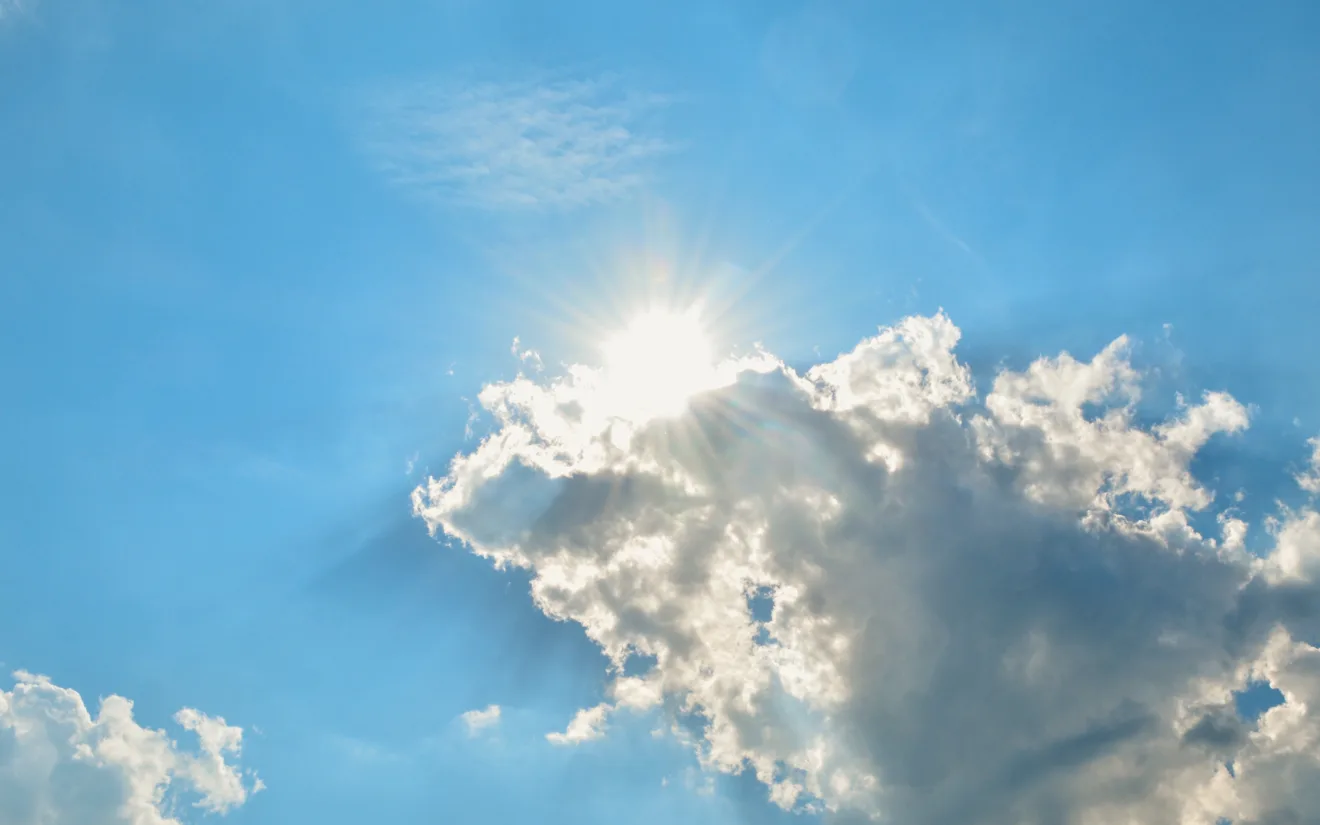 Foto de nuvem cobrindo o sol em céu azul.